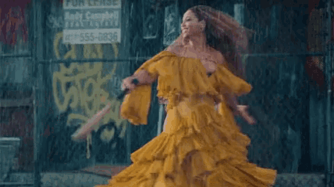 a woman in a yellow dress is holding a baseball bat in the rain