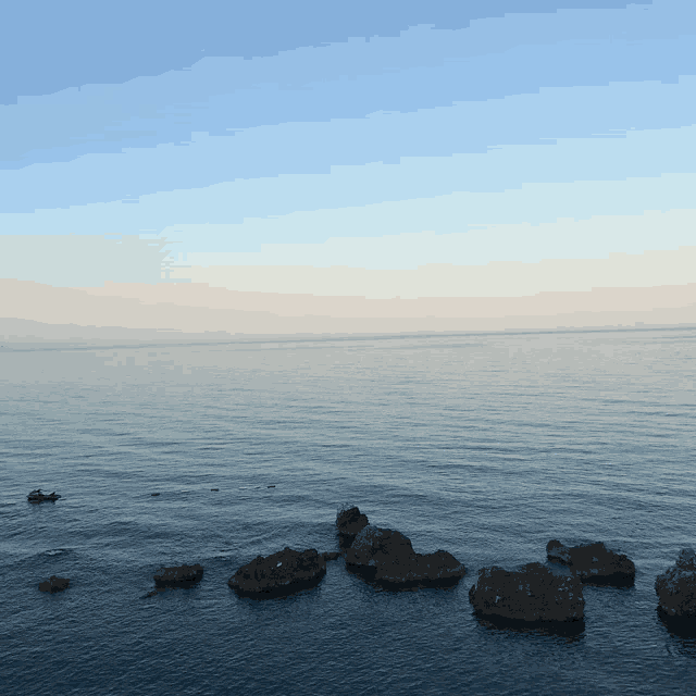 a large body of water with rocks in the water