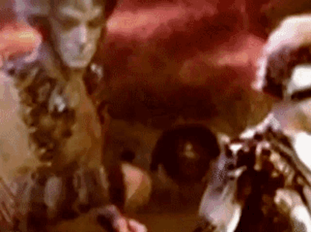 a blurry picture of two people standing next to each other .