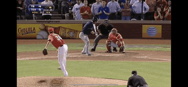 a baseball game is being played in front of an ad for cholula beer