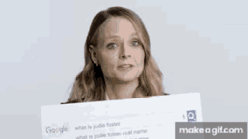 a woman is holding up a sign that says google on it