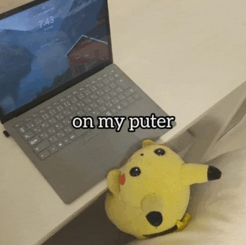 a stuffed pikachu sits next to a laptop that says on my puter on it