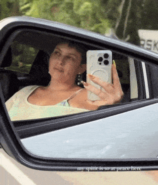 a woman taking a selfie in a car with the words " my spirit is so at peace here "