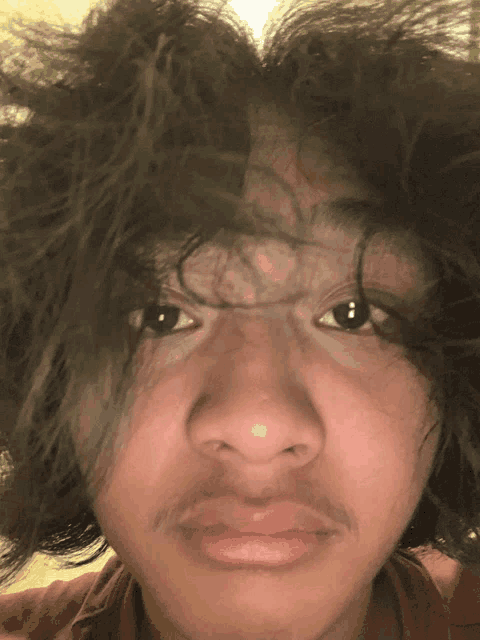 a close up of a person 's face with a mustache and long hair