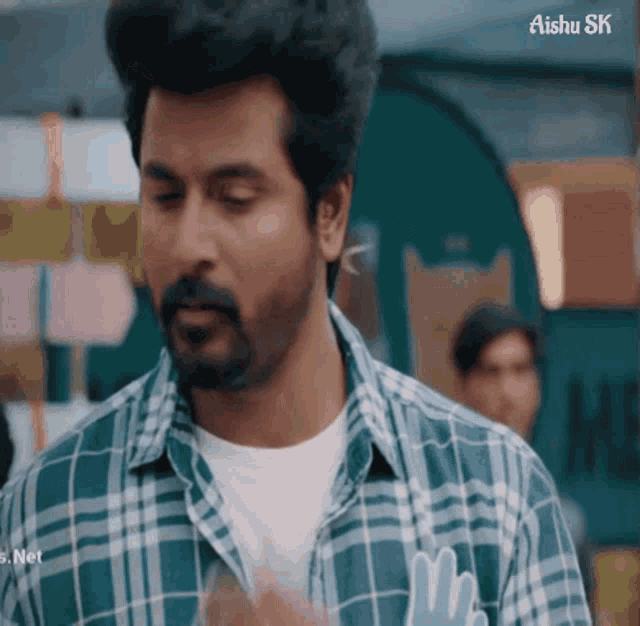 a man wearing a plaid shirt with the word mr. on his shirt