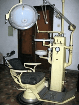 an old dental chair with a sink and a light