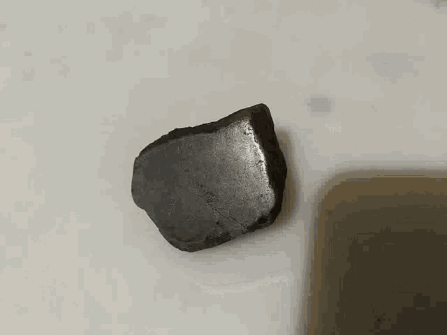 a small piece of rock is on a white surface .