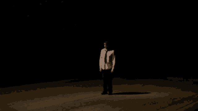 a man in a white shirt and tie is standing with his arms outstretched