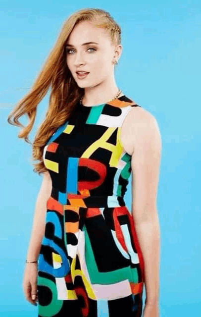 a woman is wearing a colorful dress with letters on it .