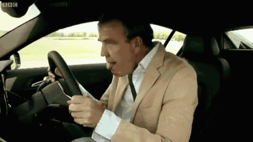 a man in a suit is driving a car with bbc written on the bottom of the screen