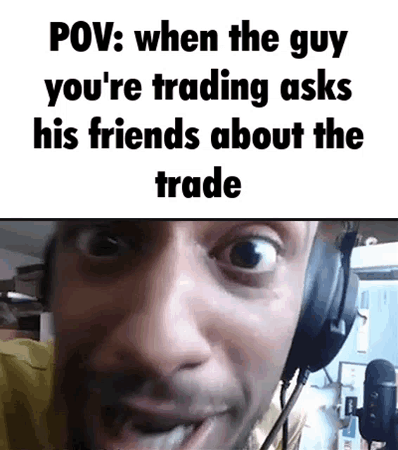 a man is wearing headphones and making a funny face while talking to his friends about the trade .