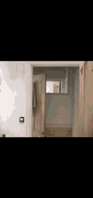 an older man in a suit and tie is standing in a doorway holding a hammer .