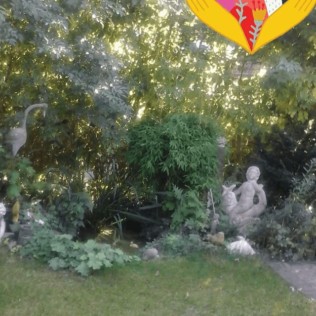 a garden with a statue of a woman holding a baby in her lap