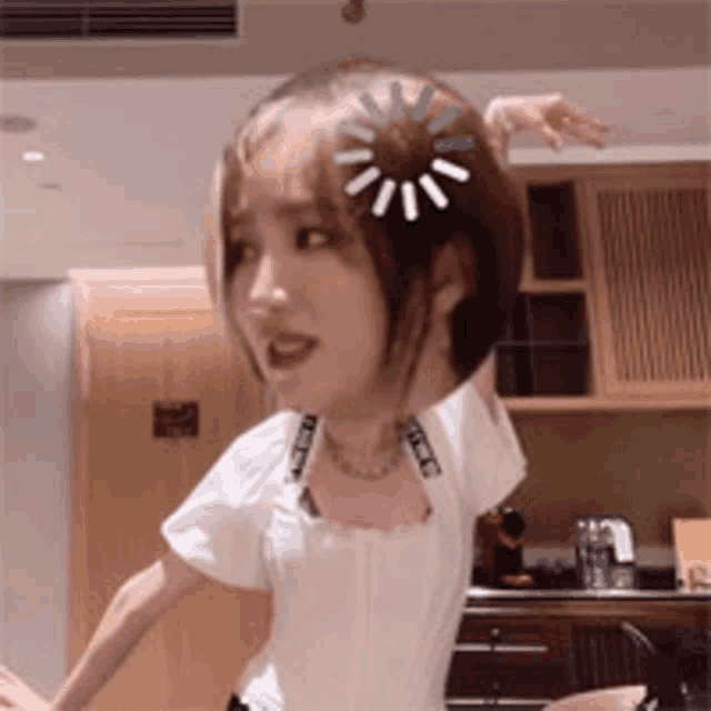 a woman is dancing in a kitchen with a loading bar on her hair .