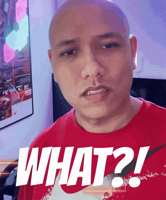 a bald man is wearing a red shirt that says what