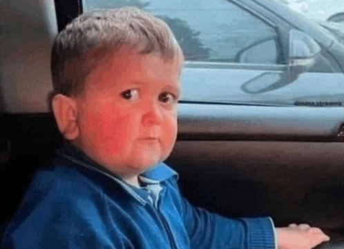 a little boy with red spots on his face is sitting in the back seat of a car .