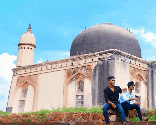 two men are sitting in front of a building with a dome