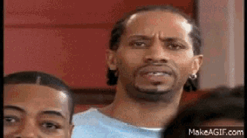 a man with a beard is standing in a crowd of people .