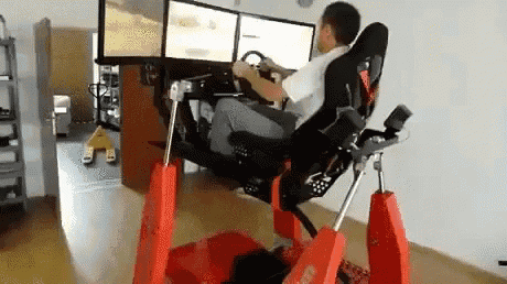 a man is sitting in a chair playing a video game with three monitors .