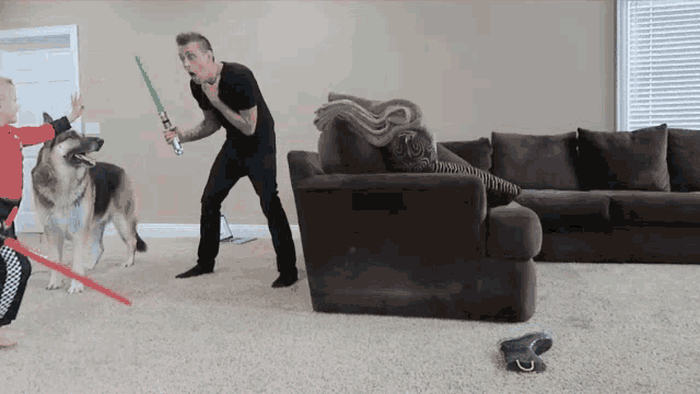 a man is holding a light saber in front of a dog and a child