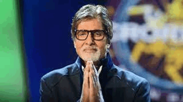 a man with glasses and a beard is praying with his hands folded in front of a green screen .