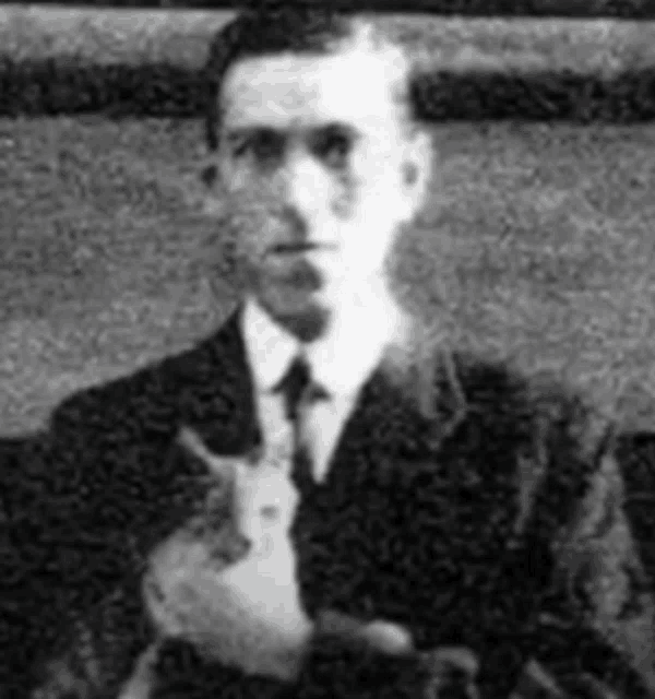 a man in a suit and tie is holding a cat in his arms .