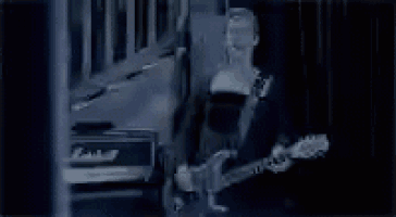 a woman is playing a guitar in a dark room