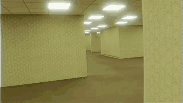 a very long hallway with a lot of empty walls and carpet .