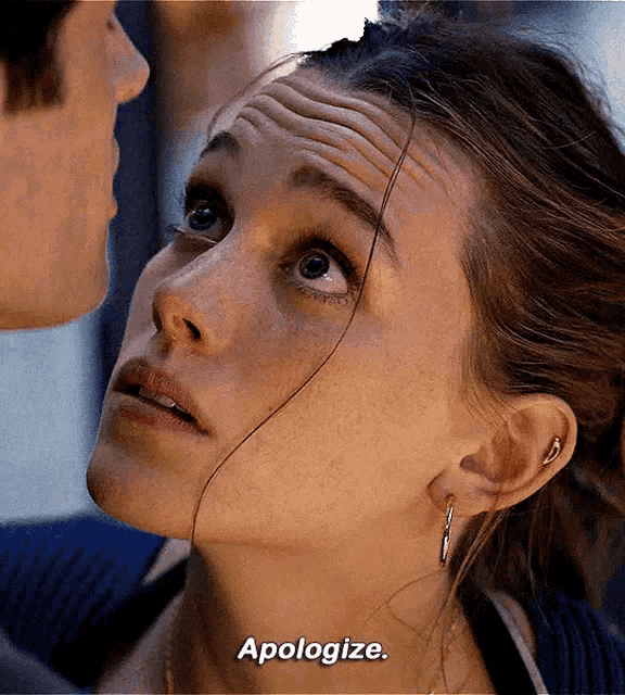 a close up of a woman 's face with the words apologize written below her