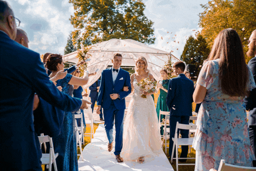 a bride and groom are walking down the aisle at a wedding