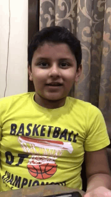 a young boy wearing a yellow basketball t-shirt