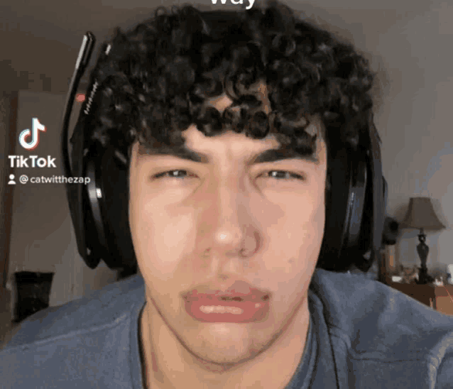 a man with curly hair wearing headphones and a tiktok logo on his face