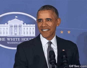 a man in a suit and tie is standing in front of two microphones in front of the white house .