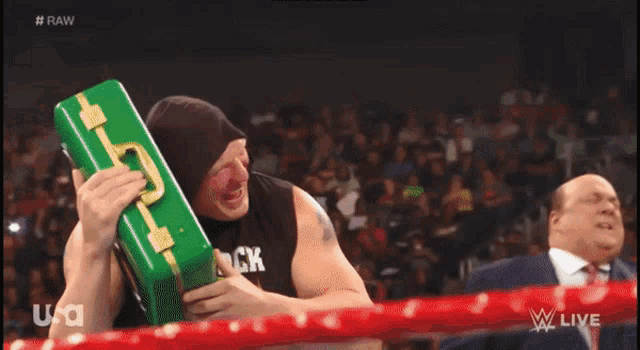 a man wearing a black shirt that says party is holding a green box