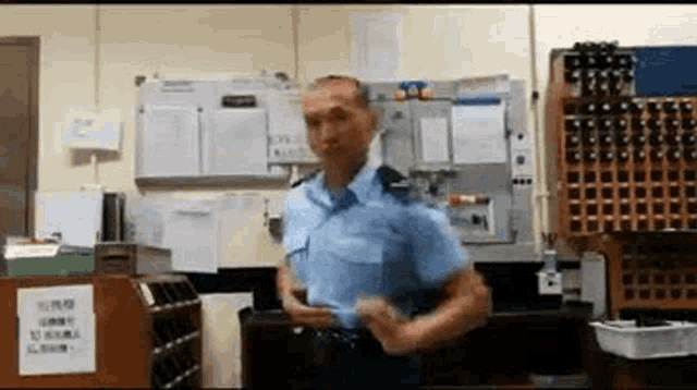 a man in a police uniform is standing in a room with a sign on the wall that says no smoking