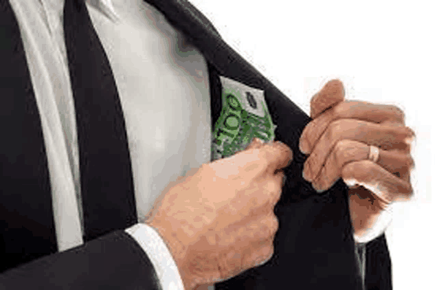 a man in a suit and tie is putting money in his pocket .