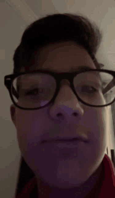 a close up of a person wearing glasses and making a funny face .