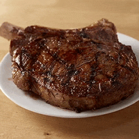 a steak on a white plate on a table