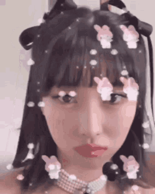 a close up of a woman 's face with bunny ears on her hair and a choker .