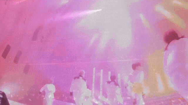 a group of men are playing instruments on a stage with purple lights