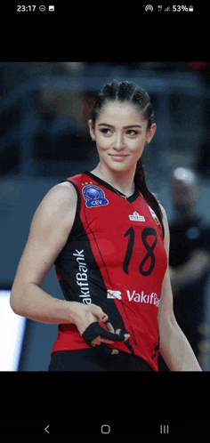 a female volleyball player wearing a red and black uniform with the number 18 on it