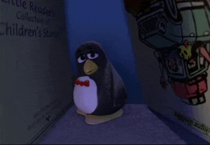 a stuffed penguin with a bow tie is sitting in front of a children 's book .