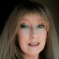 a close up of a woman 's face with long hair and a fringe .