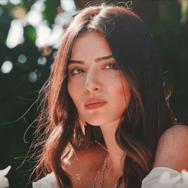 a close up of a woman 's face with the sun shining through her hair