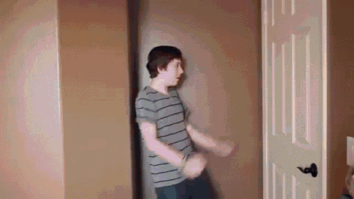 a young boy is dancing in front of a door .
