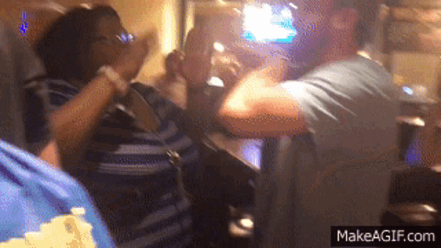 a group of people are dancing in a room with a makeagif.com watermark