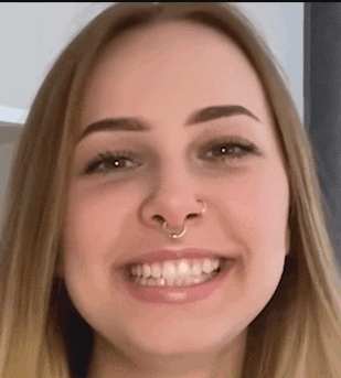 a woman with a nose ring is smiling for the camera