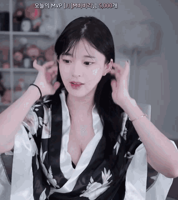 a woman in a black and white kimono with chinese writing on the bottom right