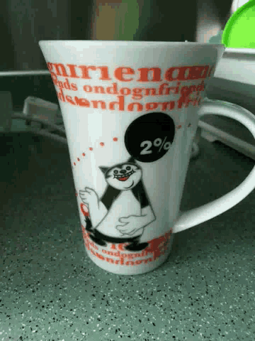 a coffee mug with a cartoon cat and the words " vrienden " on the side