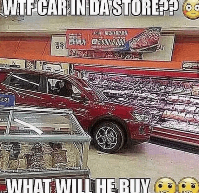 a red car is parked in a grocery store with a sign that says wtf car in da store .